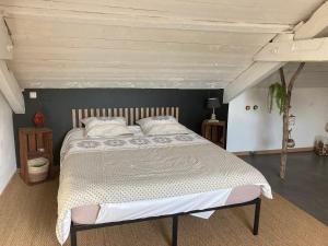 a bedroom with a large bed with a wooden headboard at GITE Voie Verte , jardin, CV LOUHANS in Louhans