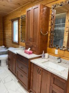 een badkamer met 2 wastafels en een toilet in een cabine bij Geese Villa Log House in Harrington