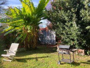 a grill and two chairs in a yard at GITE Voie Verte , jardin, CV LOUHANS in Louhans
