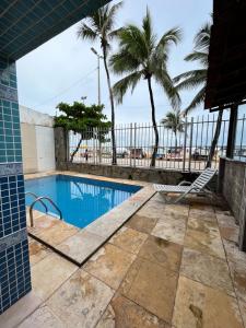 a swimming pool with palm trees and a view of the ocean at Sonho de Iracema Hostel Boutique in Fortaleza