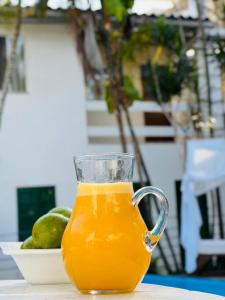 a glass of orange juice sitting on a table at Pousada Estalagem dos Corais da Prainha in Arraial do Cabo
