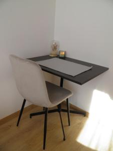 stół z białym krzesłem i czarnym biurkiem w obiekcie Agroturystyka Tęczowa Dolina w mieście Bodzentyn