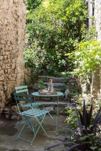 une table et une chaise dans le jardin dans l'établissement Logis de Cupidon, à Châteauneuf-du-Rhône
