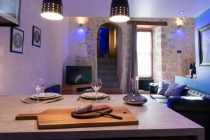 - une table à manger avec 2 assiettes et des verres à vin dans l'établissement Logis de Cupidon, à Châteauneuf-du-Rhône