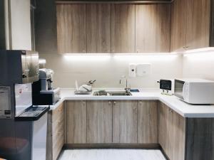 a kitchen with wooden cabinets and a sink at 日初青旅 Sundaily Hostel 北車 in Taipei
