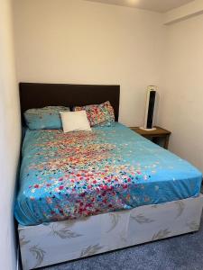 a bed with a blue comforter with sprinkles on it at Hastings street in Luton