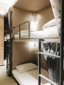 日初青旅 Sundaily Hostel 北車 في تايبيه: غرفة بسريرين بطابقين وسرير