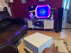 a person sitting in front of a tv in a living room at Hastings street in Luton