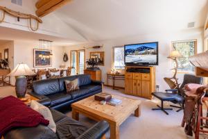 een woonkamer met een bank en een tv bij Warm Springs Ski Way Home with Pool, Pickleball, and More! in Ketchum