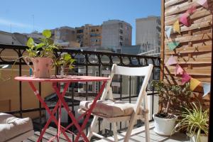 una mesa roja y 2 sillas en el balcón en Buen Aire, en Cagliari
