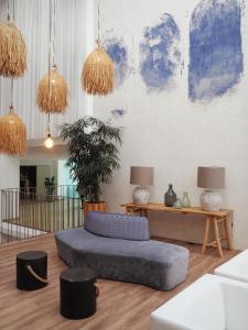 uma sala de estar com um grande sofá azul e candeeiros em The Views Oasis no Caniço