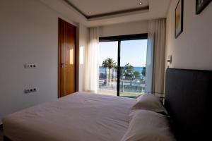 a bedroom with a bed and a large window at Dassine View - Luxe - Agadir - 5 Px in Agadir