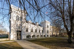 文茨皮尔斯Villa Langberg Spa的前面有旗帜的大型白色建筑