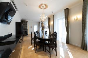 uma sala de jantar com uma mesa e cadeiras e um lustre em Villa Langberg Spa em Ventspils