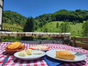 a table with plates of food on a checkered table cloth at Serendipity Apartment in Brzeće
