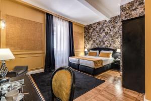 um quarto de hotel com uma cama e uma secretária em Relais Fontana Di Trevi Hotel em Roma