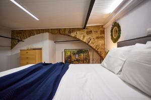 a bedroom with a large bed with a stone wall at The Wine House in Chios