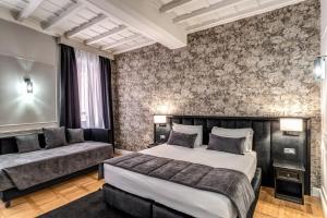 a bedroom with a large bed and a couch at Relais Fontana Di Trevi Hotel in Rome