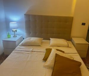 a large white bed in a room with a lamp at Beira Mar AB2 in Santa Maria
