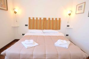 a bedroom with a large bed with towels on it at Case VR Holiday - Residenza Leo in Verona