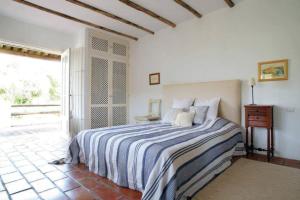 um quarto com uma cama com um cobertor listrado azul e branco em Charming Country House in Silves em São Bartolomeu de Messines