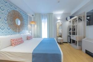 a bedroom with a large bed with a blue wall at Soho Boutique Cádiz in Cádiz