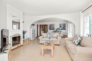 a living room with white furniture and a fireplace at Villa Cayetana in Mahón