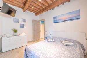 a white bedroom with a bed and a tv at Piombino Apartments - Casa XX Settembre in Piombino