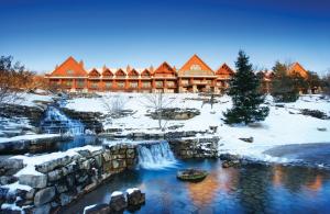 a lodge in the snow with a waterfall in front at Branson Condo at Thousand Hills Walkin with Elevator Golf Front near 76 Strip in Branson
