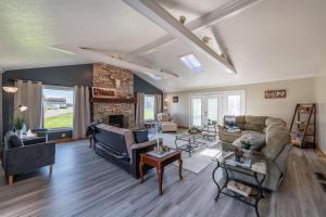 a living room with two couches and a fireplace at Maplewood Farmhouse + Hot tub in Howland Corners