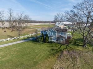 an aerial view of a blue house in a field at Maplewood Farmhouse + Hot tub in Howland Corners