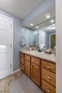 a bathroom with a sink and a large mirror at Maplewood Farmhouse + Hot tub in Howland Corners