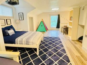 ロジャースにあるBeaver Lake Modern Getaway -3 bedroom houseのベッドと緑のクリスマスツリーのある寝室