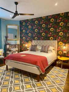 Maison Belmont Eymet في إيميت: غرفة نوم بسرير كبير وبجدار ورد