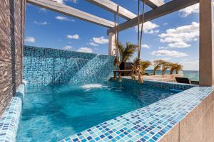 a swimming pool with blue tile on the side of a building at Ocean Plaza by Zamá Homes in Playa del Carmen