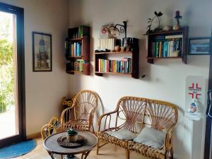 una stanza con due sedie e un tavolo e librerie di Hotel Grotticelli a Scopello