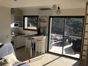 een kleine keuken met een tafel en een balkon bij Studio au calme, grande terrasse avec vue vallée in Ginasservis