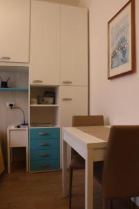 a kitchen with a table and a white cabinet at Beautiful lake in Garda