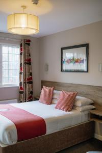 a bedroom with a large bed with red and white pillows at Red Mullions Guest House in Oxford
