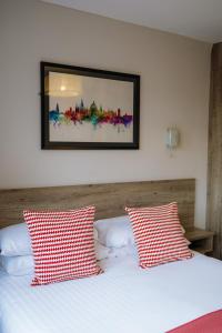 a bedroom with a bed with two red and white pillows at Red Mullions Guest House in Oxford