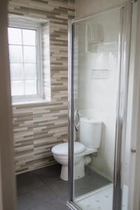 a bathroom with a toilet and a glass shower at Red Mullions Guest House in Oxford