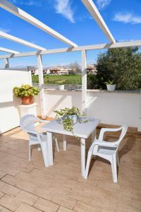 einen weißen Tisch und Stühle auf einer Terrasse in der Unterkunft Casa Donna di Cuori in Fiumicino