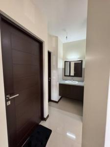 een badkamer met een bruine deur en een wastafel bij apartamento completo in Cochabamba
