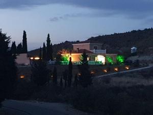 uma casa iluminada à noite com luzes verdes em Cresta Azul em Antas