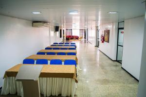 阿拉皮拉卡的住宿－Hotel Pequeno Principe，走廊里一排带蓝色椅子的桌子