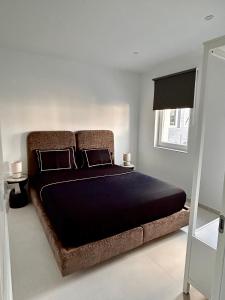 um quarto com uma cama grande com lençóis pretos e uma janela em Phoenix garden em Mons