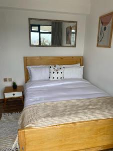 a bedroom with a wooden bed with a window at 1bedroom Exquisite City Apartment in Kilimani by The Manna Stays in Nairobi