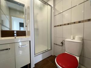 La salle de bains est pourvue de toilettes rouges et d'une douche en verre. dans l'établissement #Le Mignon Calme & Reposant WIFI-TV Parking, à Illzach