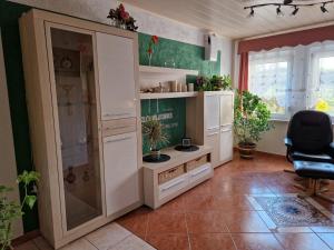 a kitchen with white cabinets and a chair in a room at Ferienwohnung Am Öpitzer Berg in Pößneck