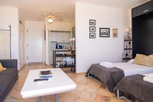 ein Wohnzimmer mit einem Bett, einem Sofa und einem Tisch in der Unterkunft OleHolidays 655 Romana Playa vistas al mar in Marbella